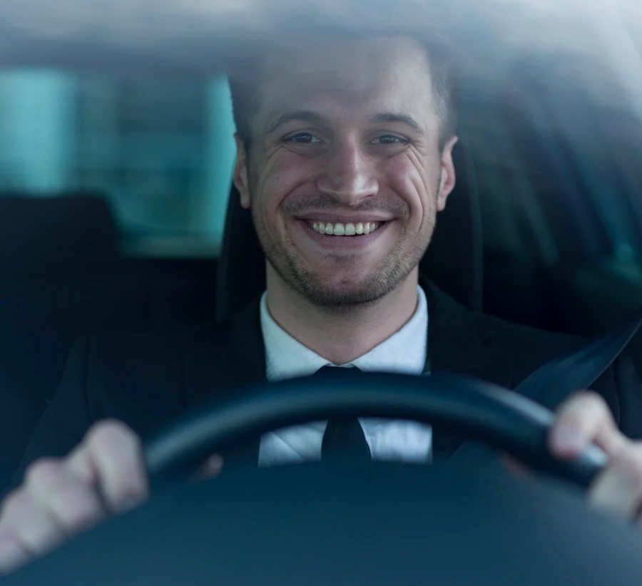 Motoristas sorridentes dirigindo carros, simbolizando segurança, conforto e confiança na locação de veículos.